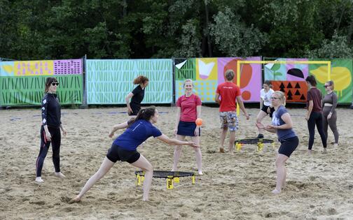 Sporters op het strand die spikeball spelen